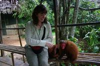 Jess grins at an endangered Red-faced Uakari Monkey (Cacajao calvus rubicundus) while simultaneo...